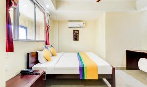 a bedroom with a bed and a window at Itsy By Treebo - Aditya in Nagpur