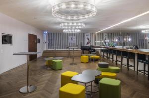 a lobby with tables and chairs and a bar at MAXX by Steigenberger Vienna in Vienna