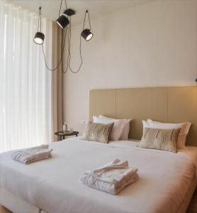 a bedroom with two towels on a large bed at Aroeira Lisbon Hotel - Sea & Golf in Aroeira