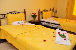 a bedroom with two beds with flowers on them at Hotel Ribis in Ait Melloul