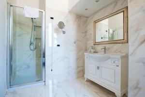 W łazience znajduje się prysznic, umywalka i lustro. w obiekcie Royal House w Rzymie