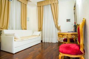 un soggiorno con divano bianco e sedia rossa di Royal House a Roma