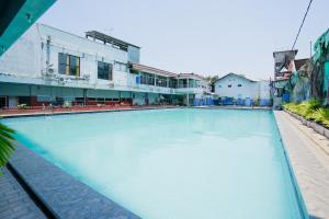 a large pool of blue water with buildings in the background at OYO 1652 Hotel Tampiarto in Probolinggo