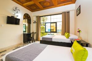 Una habitación de hotel con dos camas y una ventana. en Ayenda 1411 Caney Sede Ingenio, en Cali