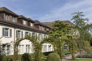 a large white building with an arch in the yard at Hotel Arenenberg in Salenstein
