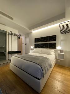 a bedroom with a large white bed and a bathroom at MYHOME 75 Premium Luxury B&B in Pescara