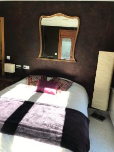 Schlafzimmer mit einem Bett und einem Spiegel an der Wand in der Unterkunft Casa Rustica Cabanes in Ordino