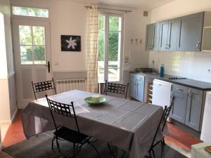 cocina con mesa con sillas y mantel en Gite du manoir de l'étang, en Marines