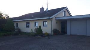 een wit huis met een garage en een oprit bij Ferienwohnung Ackermann in Engen