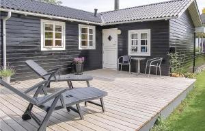 Kelstrup StrandにあるBeautiful Home In Haderslev With 3 Bedrooms And Wifiの木製デッキ(椅子、テーブル付)