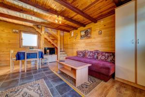 a living room with a red couch and a table at Brvnare Cirkovic in Zlatibor