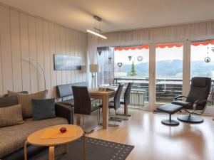 ein Wohnzimmer mit einem Sofa, einem Tisch und Stühlen in der Unterkunft Appartmentvermietung Terrassenpark Schonach in Schonach