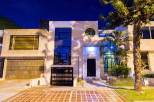 una casa blanca con una palmera delante en Ayenda 1411 Caney Sede Ingenio, en Cali