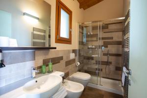 une salle de bain avec un lavabo, des toilettes et une douche dans l'établissement Cavril Agriturismo, à Sotto il Monte