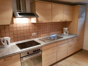 a kitchen with a sink and a stove top oven at 4 Sterne Souterrain Apartment Alt-Mariendorf in Berlin