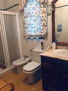 a bathroom with a toilet a sink and a shower at Arena Nest Hostel in Puerto de Santiago