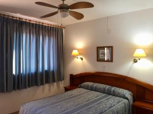 a bedroom with a bed and a ceiling fan at Casa Emilio in Torre Baja