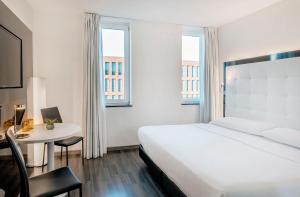 a hotel room with a bed and a desk and a table at INNSiDE by Meliá Berlin Mitte in Berlin