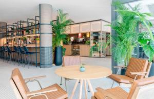 un restaurante con mesa, sillas y plantas en INNSiDE by Meliá Berlin Mitte, en Berlín