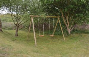 an empty swing set in a park with trees at Holiday Home Ringvejen Rømø Iii in Rømø