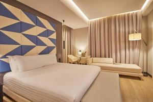 sypialnia z dużym białym łóżkiem i biurkiem w obiekcie iH Hotels Milano Ambasciatori w Mediolanie