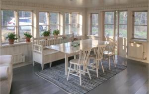 a dining room with a table and chairs and windows at Stunning Home In Nykping With 2 Bedrooms, Sauna And Wifi in Ånsund