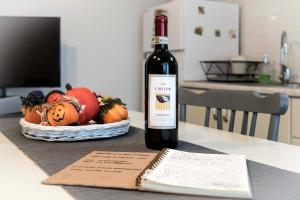 eine Flasche Wein auf einem Tisch mit einem Korb mit Kürbissen in der Unterkunft Tosca's House in Palaia