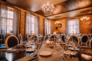 a dining room with a long table and chairs at Bahnhofs hotel in Alūksne