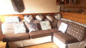 - un canapé avec des oreillers dans le salon dans l'établissement Appartement chalet PRA LOUP 1600 La sapinière, à Pra-Loup