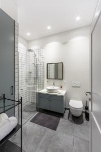 a bathroom with a sink and a toilet and a shower at Laisves ave. Apartments in Kaunas