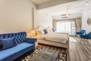 a bedroom with a bed and a blue couch at Harmony Silom in Bangkok