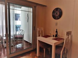 a dining room with a table and a clock on the wall at Viva San Martín, Apartamento Luminoso in Buenos Aires