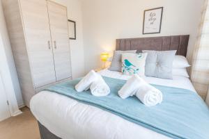 a bedroom with a large bed with towels on it at Wren Suite Apt 2 Bed 1st Floor Apt close to Oxford Business & Science Parks in Oxford