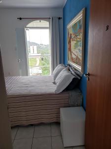 a small bedroom with a bed with a window at Hostel Equilíbrio in Florianópolis