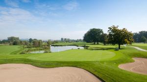 Blick auf einen Golfplatz mit einem Teich in der Unterkunft Wellness Ferienwohnung mit Bademantelgang zur Therme in Bad Griesbach