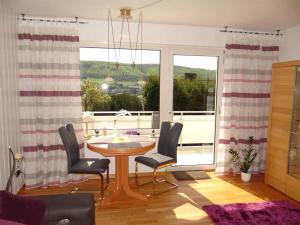 ein Esszimmer mit einem Tisch und Stühlen sowie einem Balkon in der Unterkunft Ferienwohnungen Luttmann Ausblick pur in Bad Pyrmont