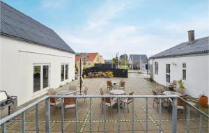 GlesborgにあるNice Home In Glesborg With House Sea Viewの中庭のパティオ(椅子、テーブル付)