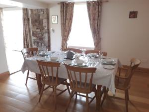a dining room with a table and chairs with glasses on it at Wellfield Farmhouse in Tipperary