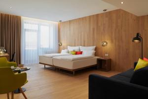 Hotel Passage في برنو: غرفة نوم بسرير ابيض كبير واريكة