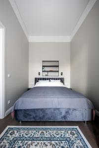 sypialnia z dużym łóżkiem z niebieską narzutą w obiekcie Laisves ave. Apartments w Kownie