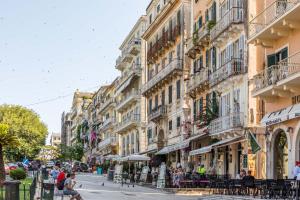 a city street with buildings and people sitting on a bench at Spianada Collection of Studios & Apartments by Konnect in Corfu
