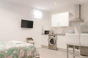 una cucina bianca con letto e lavatrice di Studio in Ruda close to Plaza Mayor & Parking Gratis a Madrid