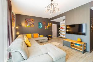 a living room with a white couch and a flat screen tv at Art Gallery Apartment in Silver Mountain in Poiana Brasov