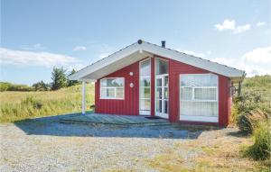 a red tiny house sitting on top of a field at 3 Bedroom Pet Friendly Home In Hirtshals in Hirtshals