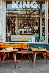 two wooden benches in front of a store window at King Kong Hostel in Rotterdam