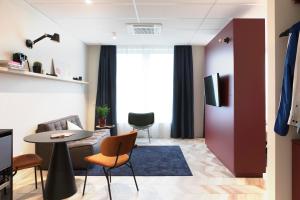 a living room with a couch and a table and chairs at ROXI The Urban Residence Brussels in Brussels
