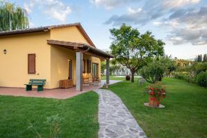 mały żółty dom z patio i dziedzińcem w obiekcie Le Rime di Campagna w Arezzo