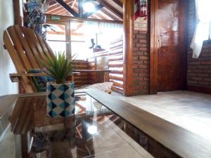 un banco de madera en una habitación con una maceta en Hostel Buenos Aires en El Calafate