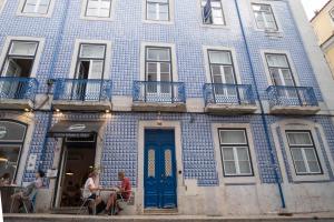 um edifício azul com pessoas sentadas à frente dele em Lisbon Alfama Tagus em Lisboa
