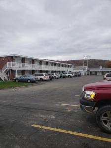 een parkeerplaats met auto's geparkeerd voor een motel bij Budget Inn Horseheads in Horseheads